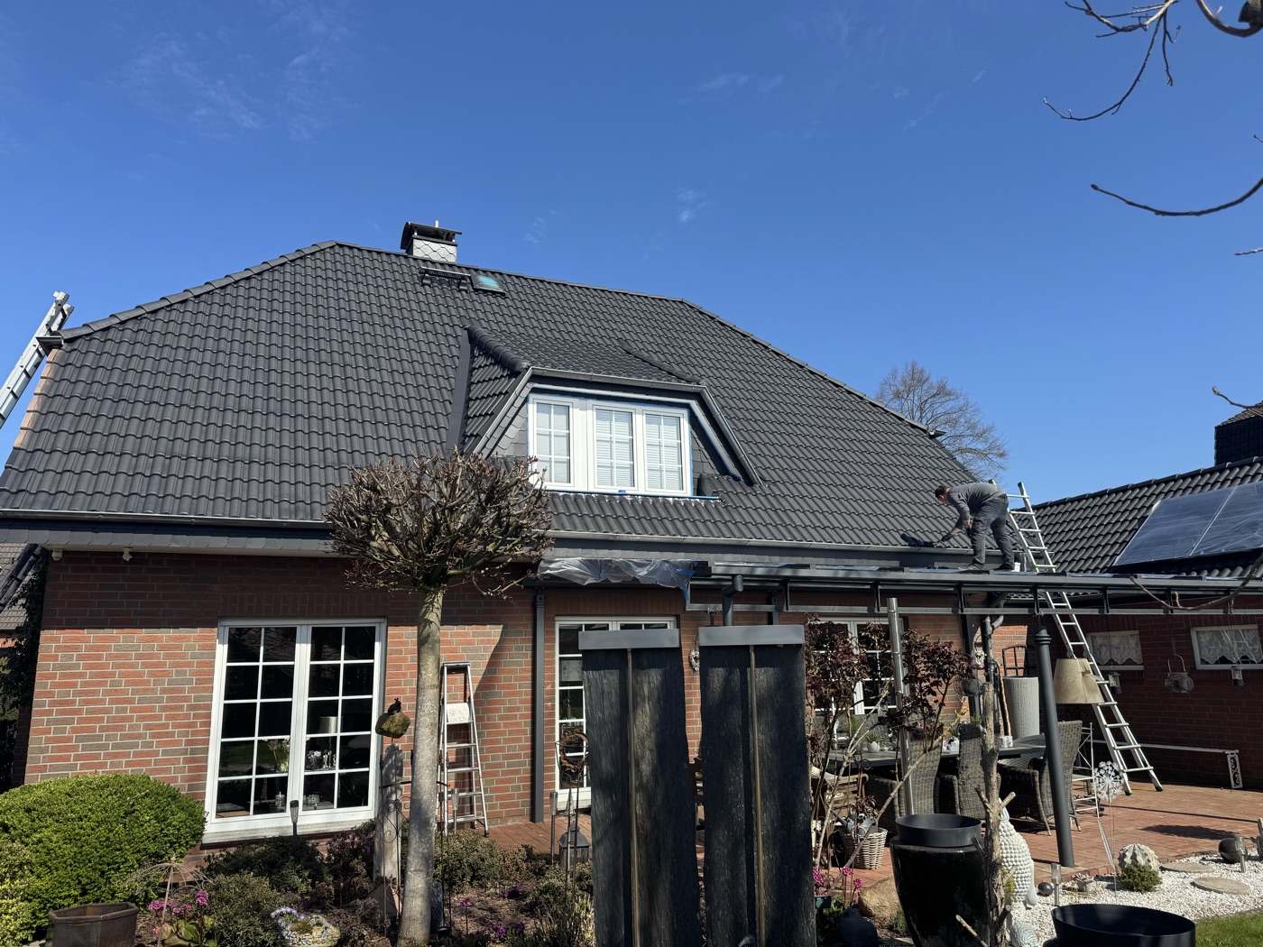 Einfamilienhaus mit fertig beschichtetem anthrazitfarbenen Dach und Terrasse